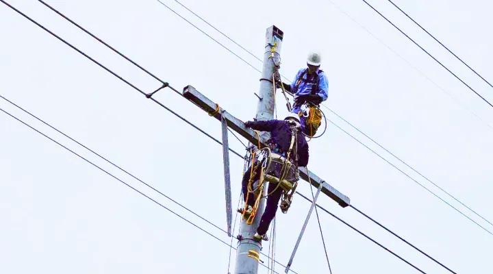 電柱に登って、電気工事をする様子